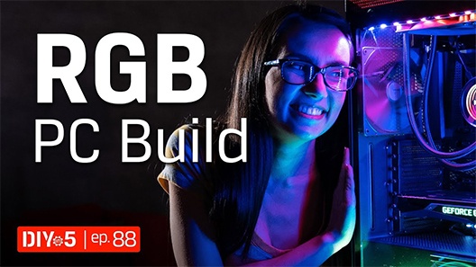 Trisha looking at an RGB PC with purple light shining on her face