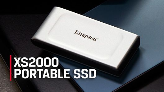 An XS2000 external SSD sits on top of a closed laptop